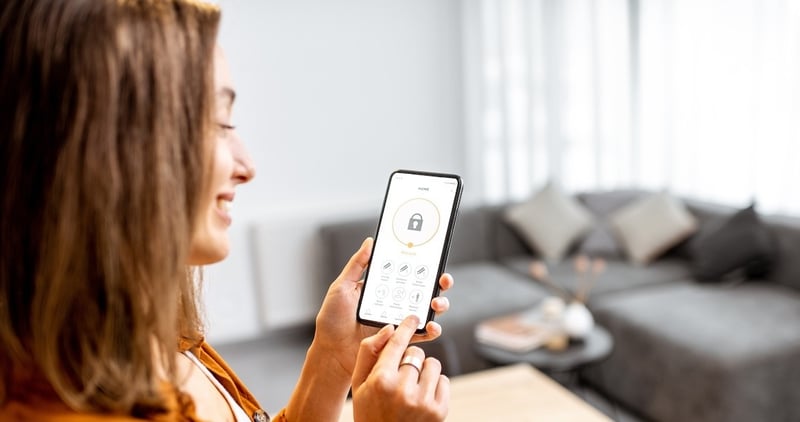 Woman looking at home security technology on mobile phone